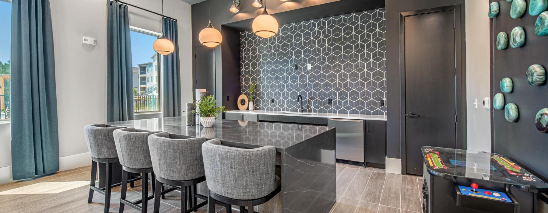 a clubhouse kitchen with a bar and chairs