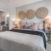a bedroom with a nightstand, dresser and a chair